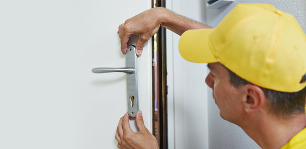 Man repairing a lock on a door